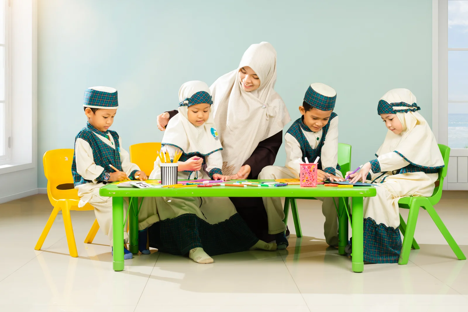 Guru mendampingi empat anak berseragam berkreasi di meja belajar